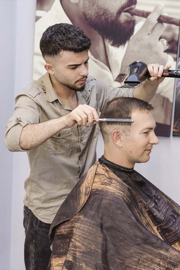 Ein junger Friseur bei der Arbeit.